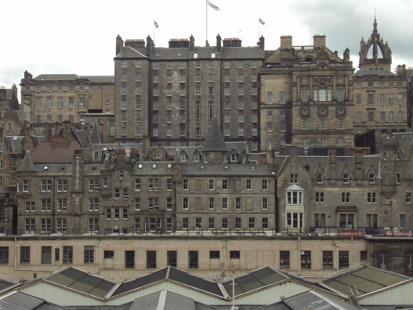 The tall rear of Edinburgh's City Chambers rising above the roofs of Waverley station, with the crown spire of St Giles' behind